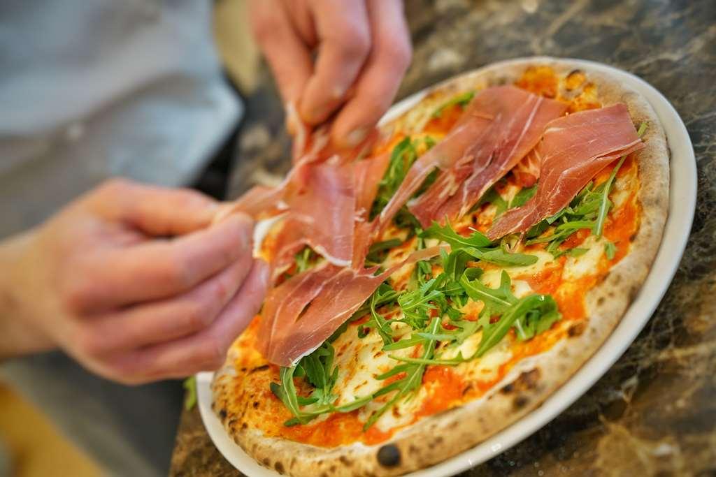 Vila Vita Rosenpark Marburg Extérieur photo Pizza being topped with prosciutto